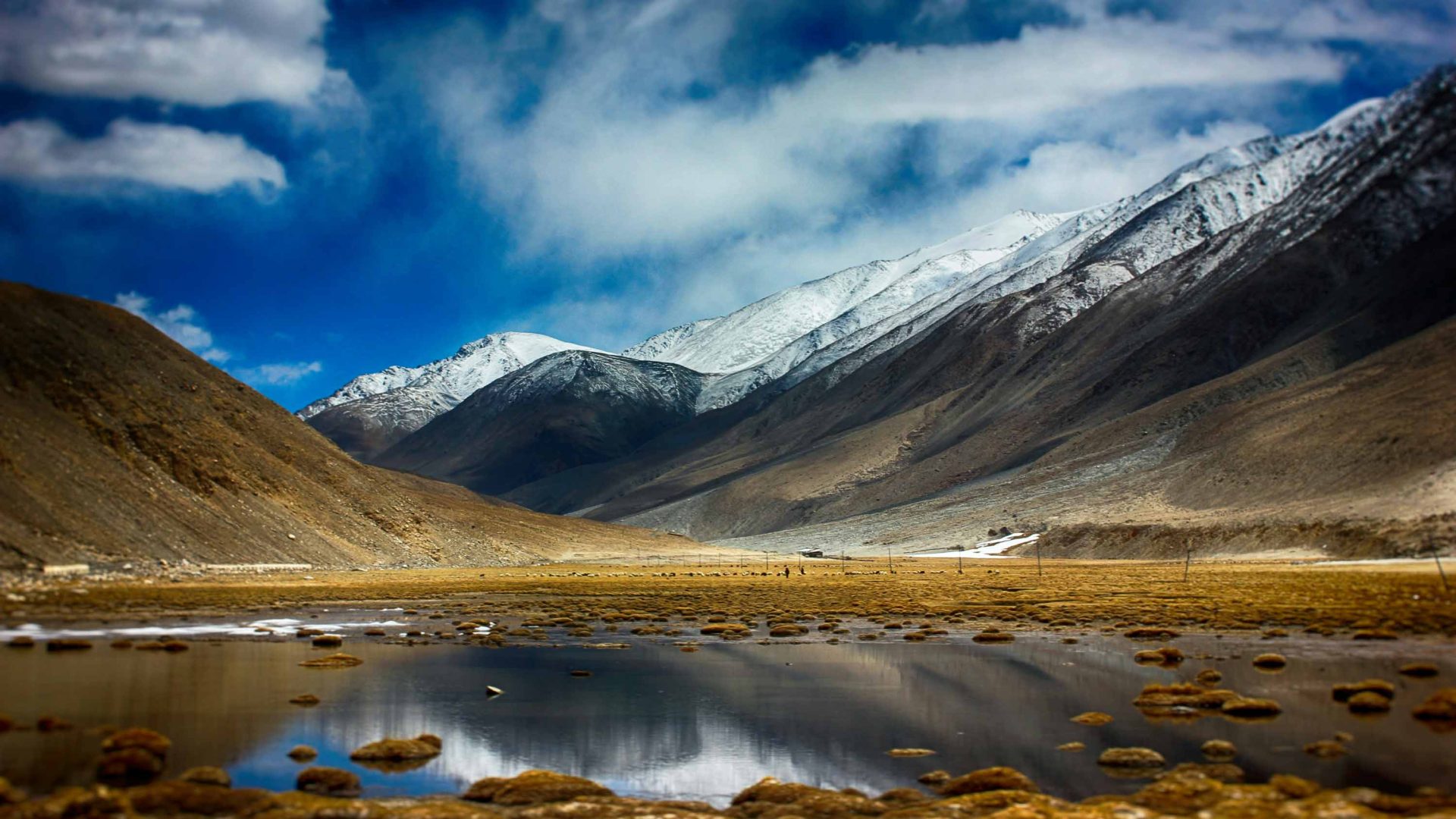 A lake below snow covered mountains.