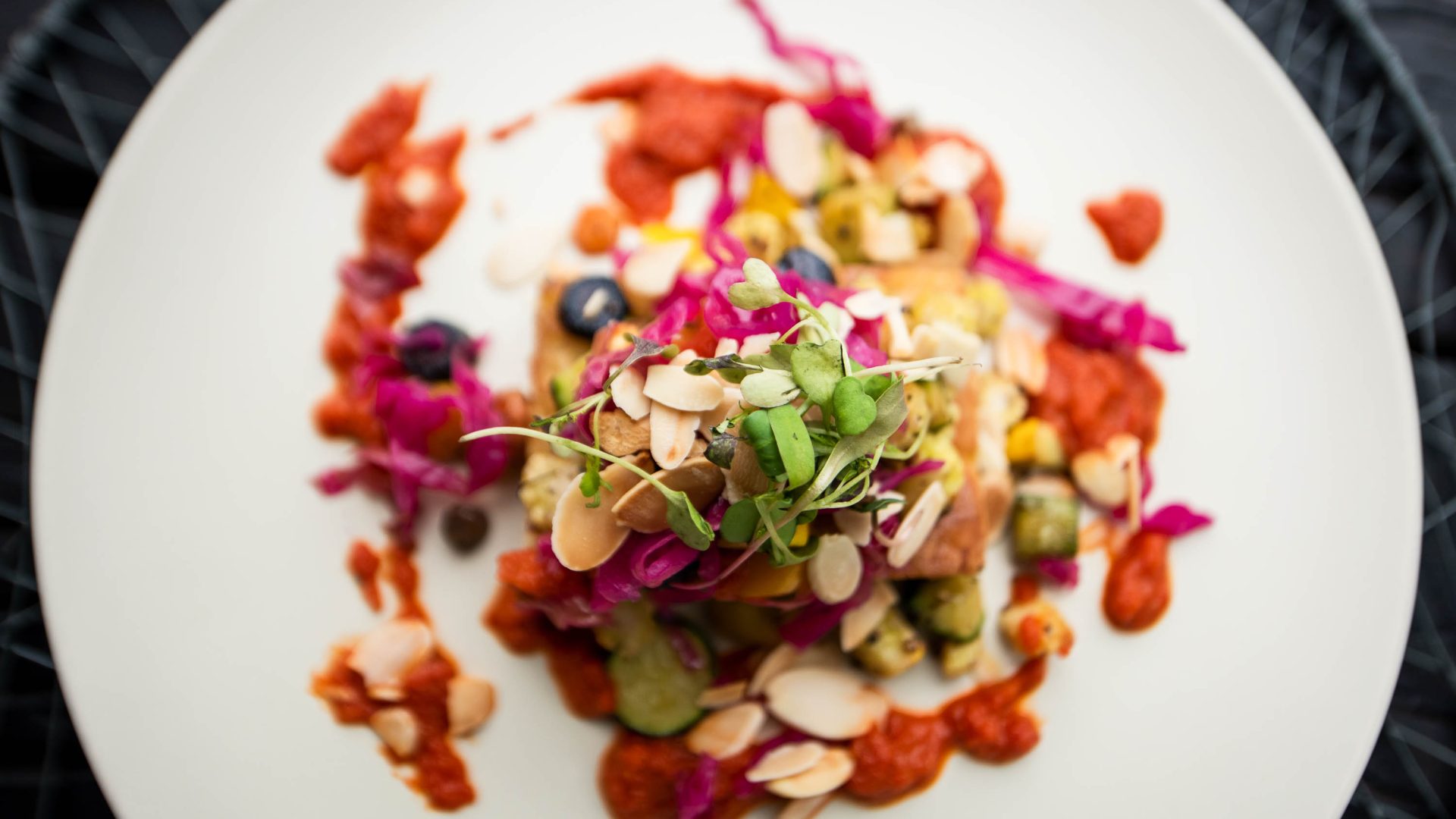 A white plate with a beautiful serving of colorful food.