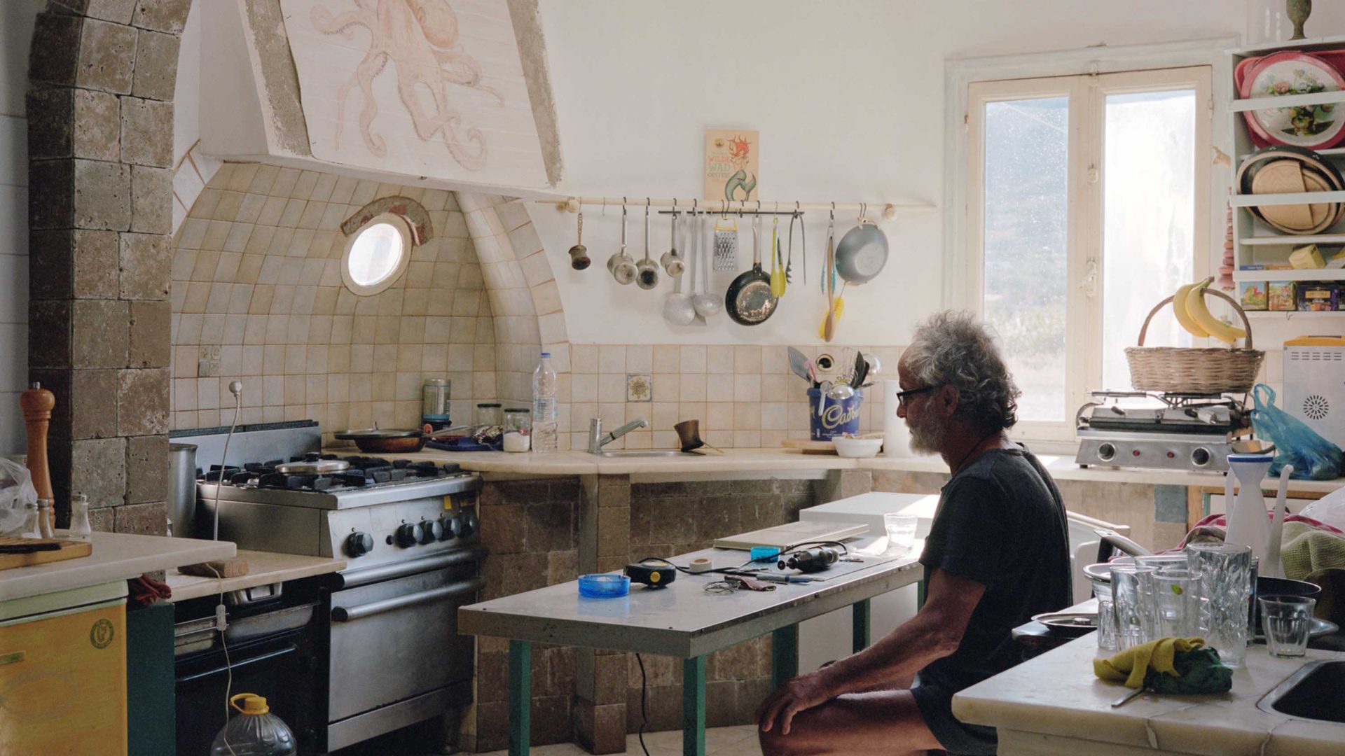 A man sits at a kitchen table.