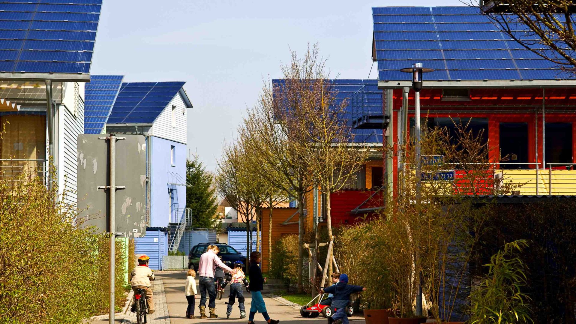 A family in a street of houses with solar power.