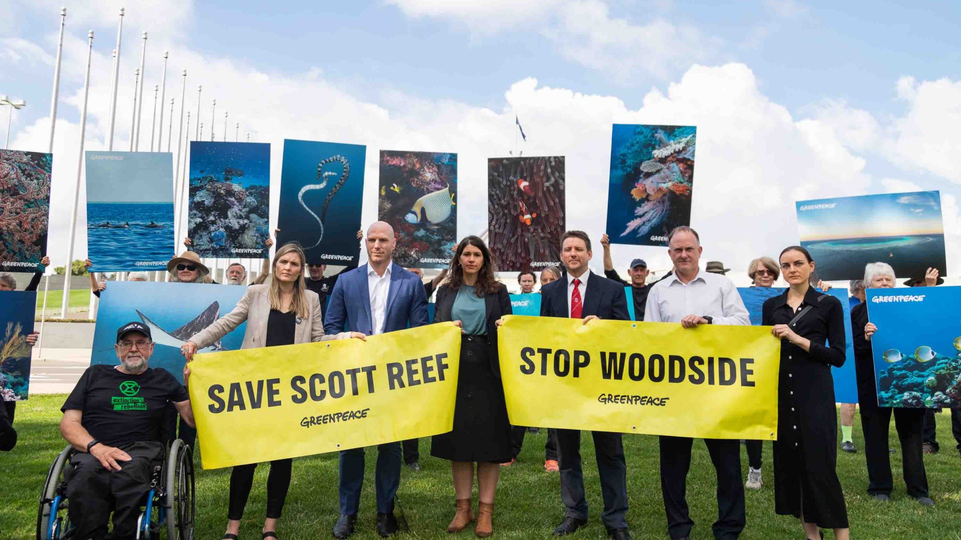 A number of people with placards and posters of the Reef stand together.