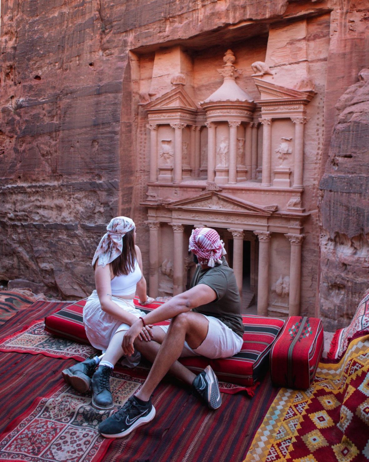 A couple holding hands against an ancient architecture backdrop