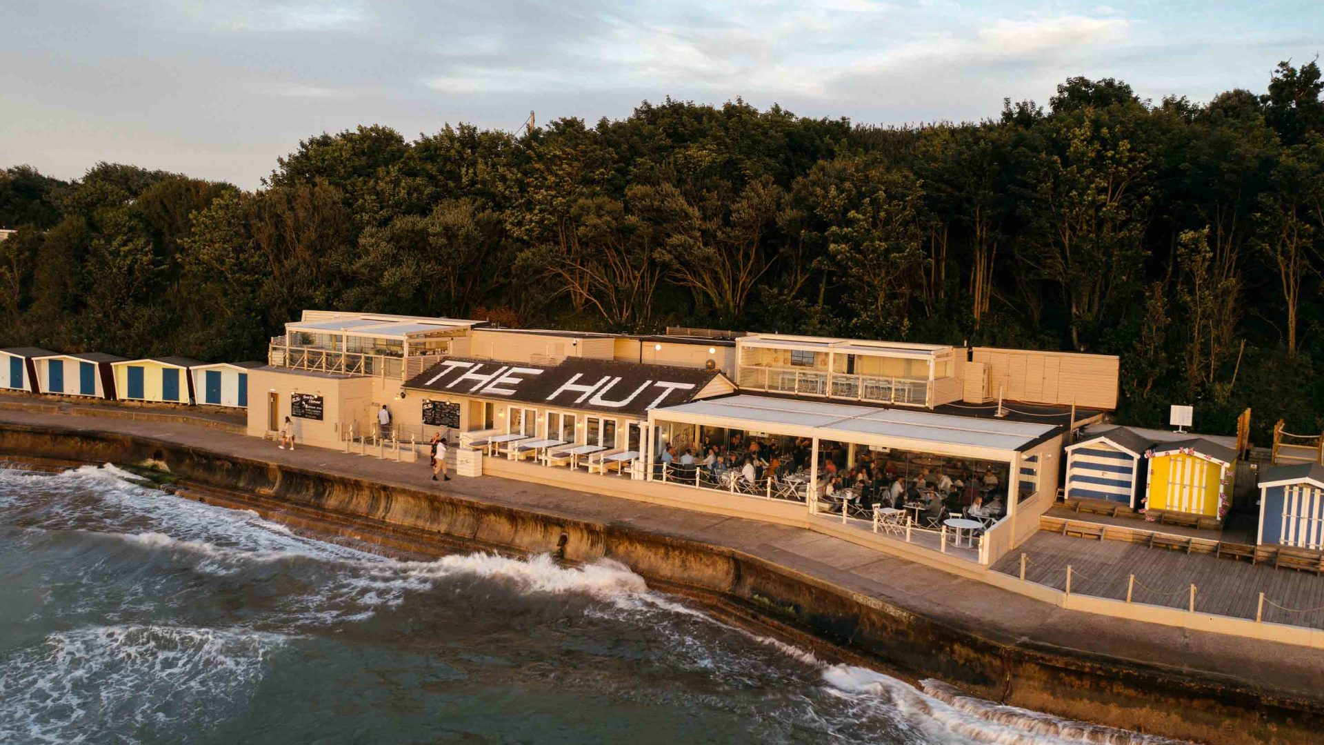 The Hut restaurant as seen from above, sits alongside the ocean.