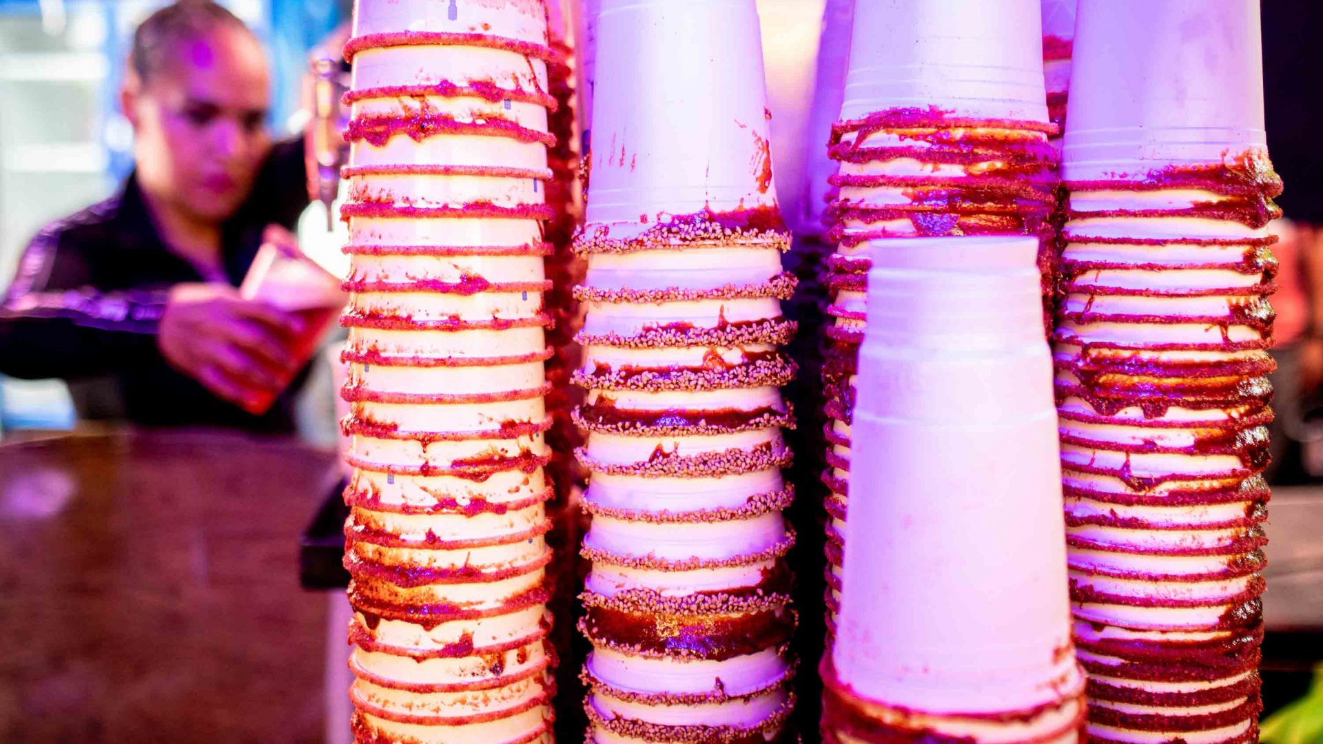 A stack of michelada cups with their rims already coated.