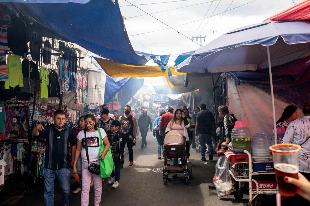 The interior of Tepito's market shows stalls and people walking.