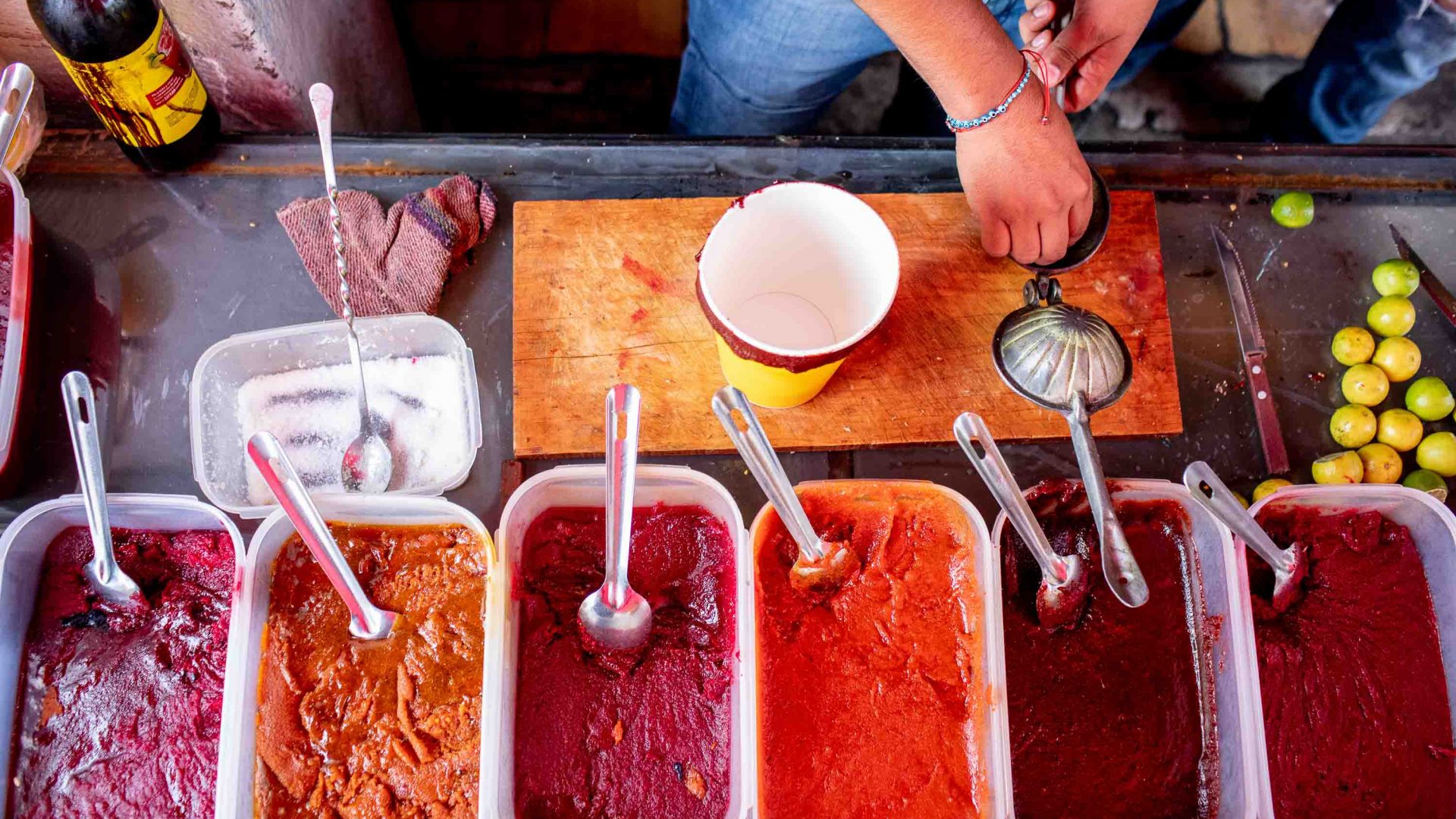 Hands can be seen preparing micheladas.