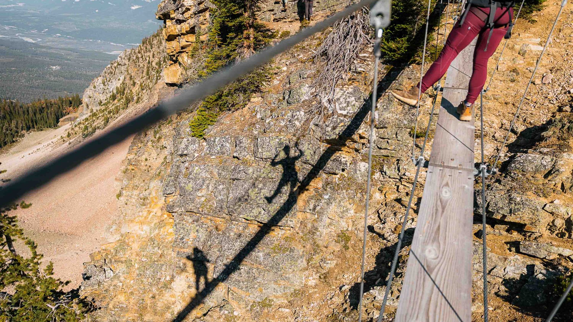 The shadows of two people on a via ferrata.