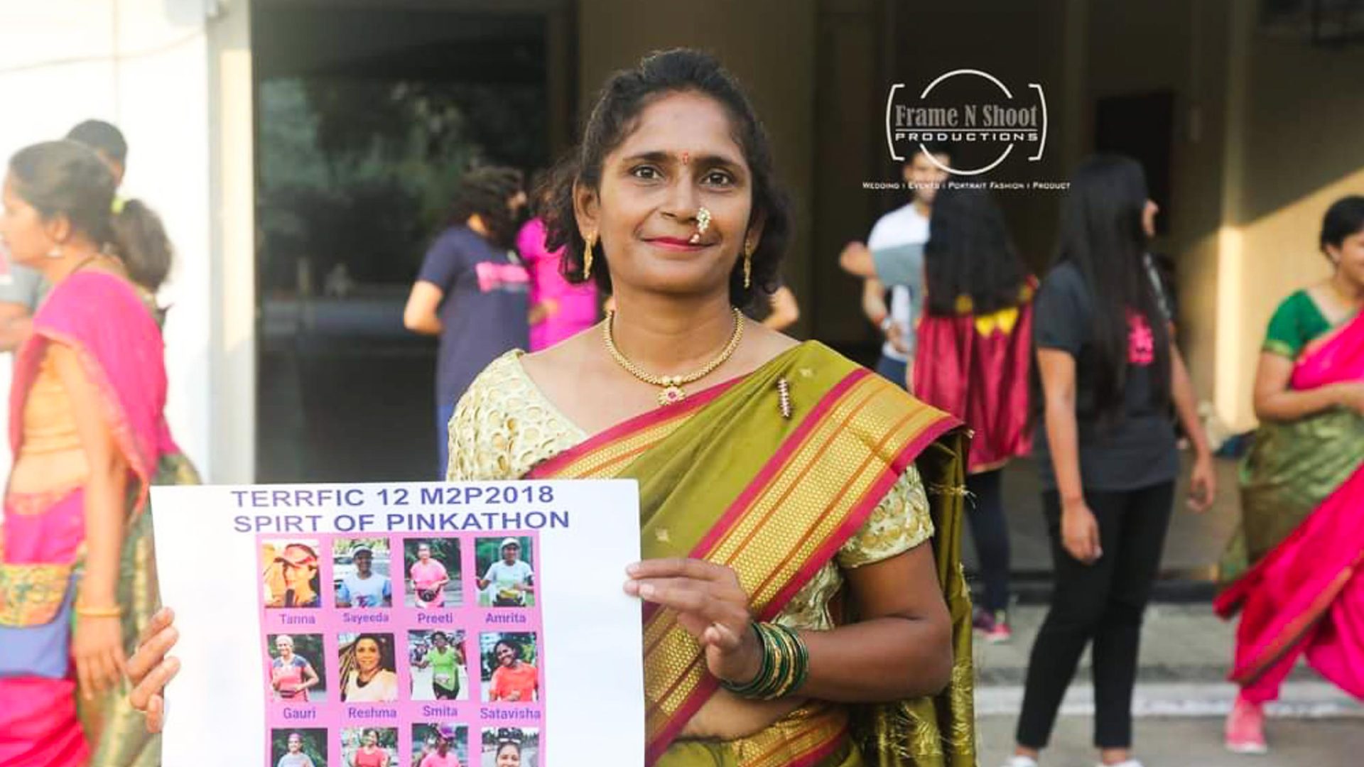 Preeti holds up an award. She is wearing a sari, having competed in a sari running event.