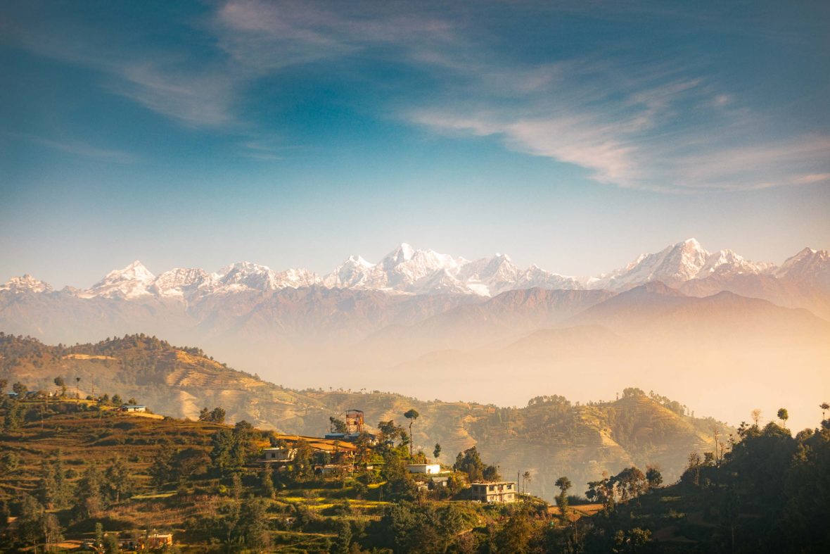 A mountain village backed by snowy mountains.