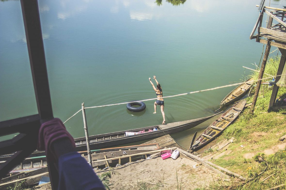 An image of a girl jumping into the river in Laos.