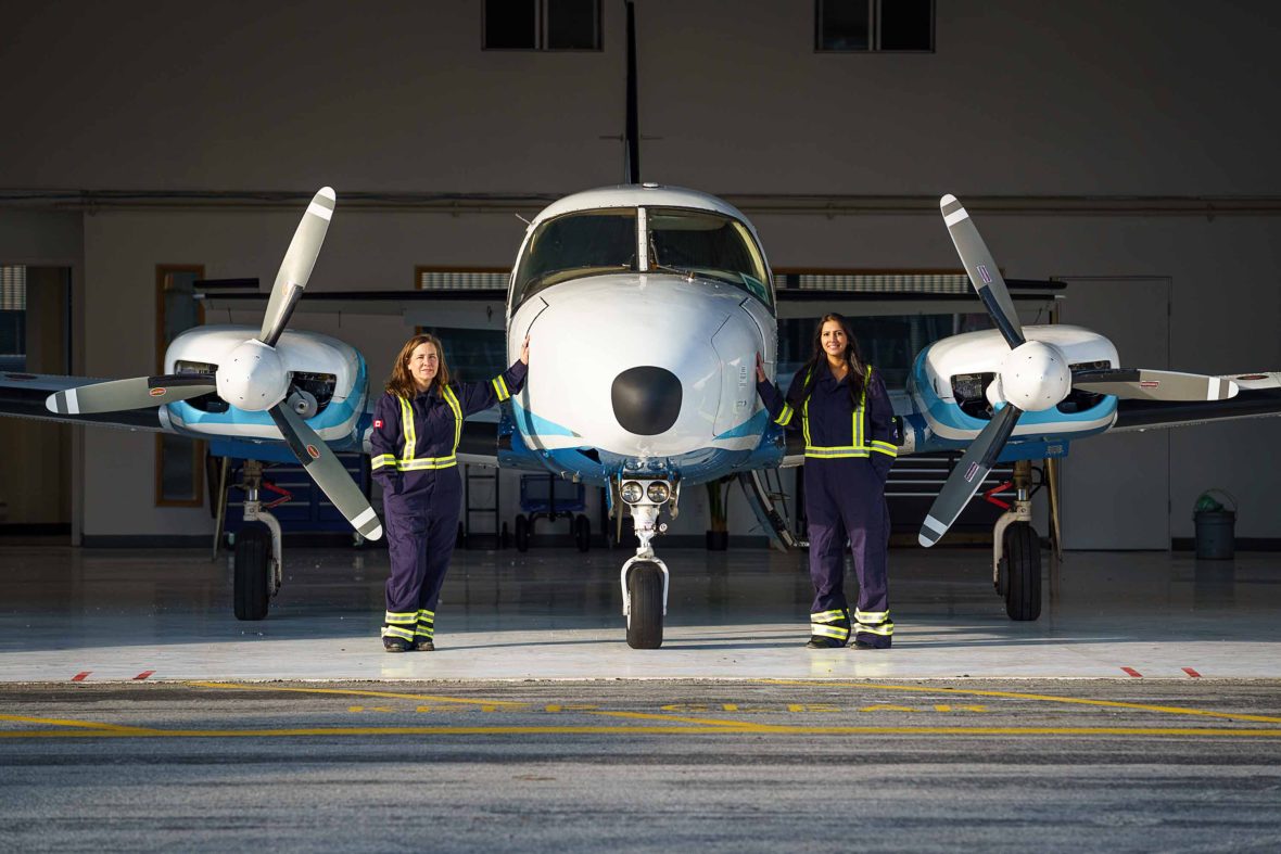 Teara and one of her staff members stand alongside one of her planes.