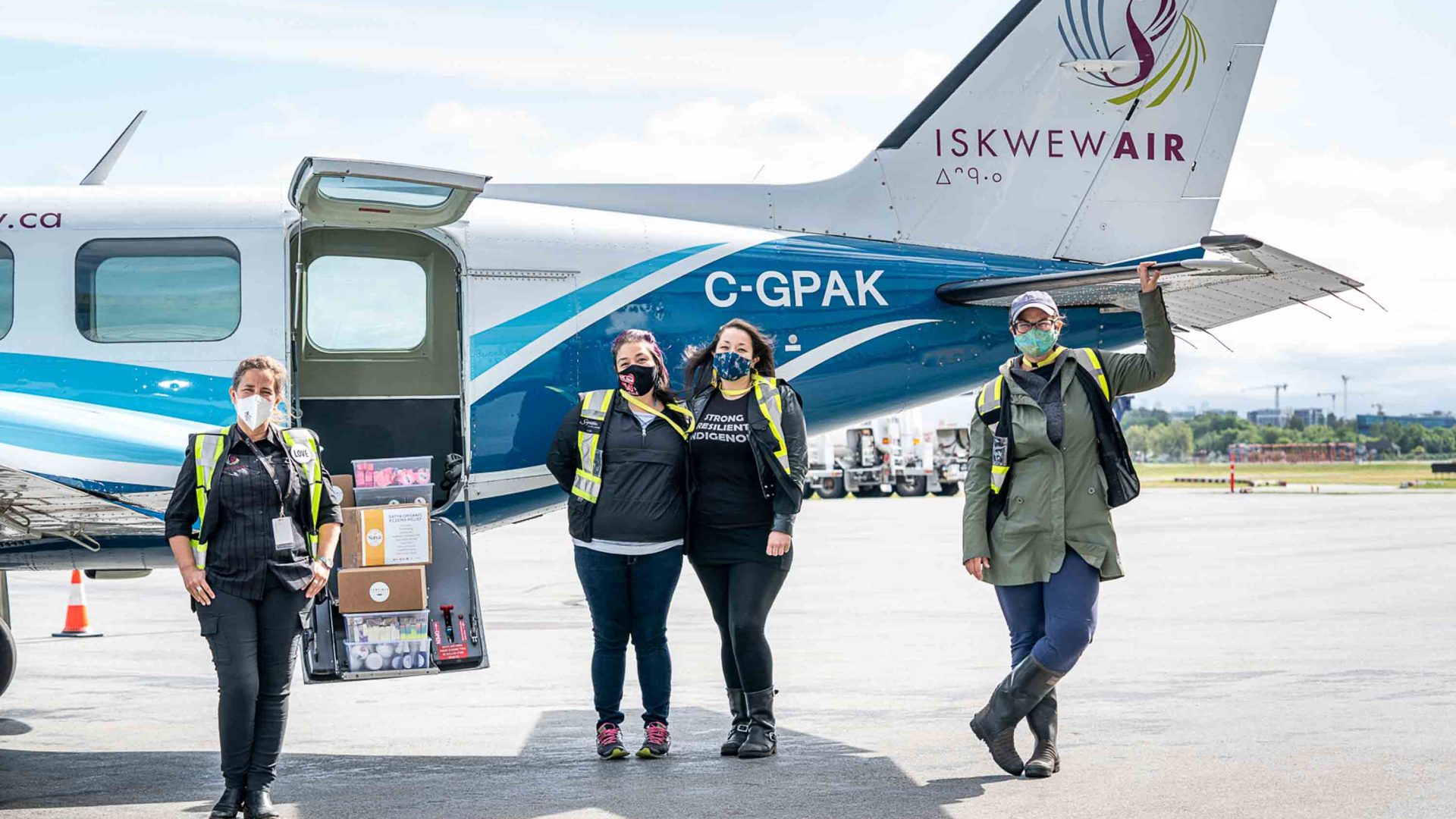 Staff stand around an Iskwew Air plane.