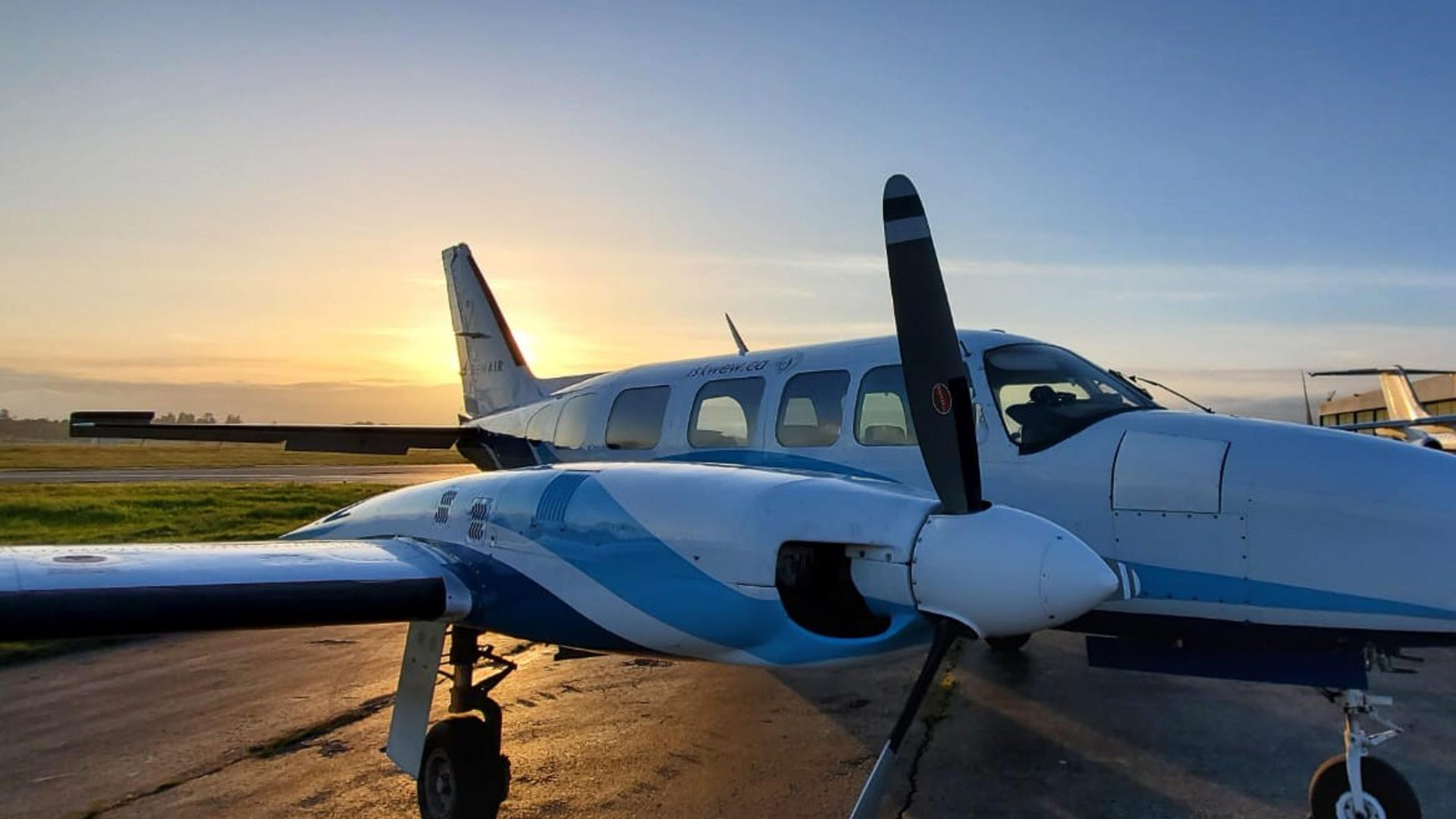 An Iskwew Air plane on the ground at sunset.