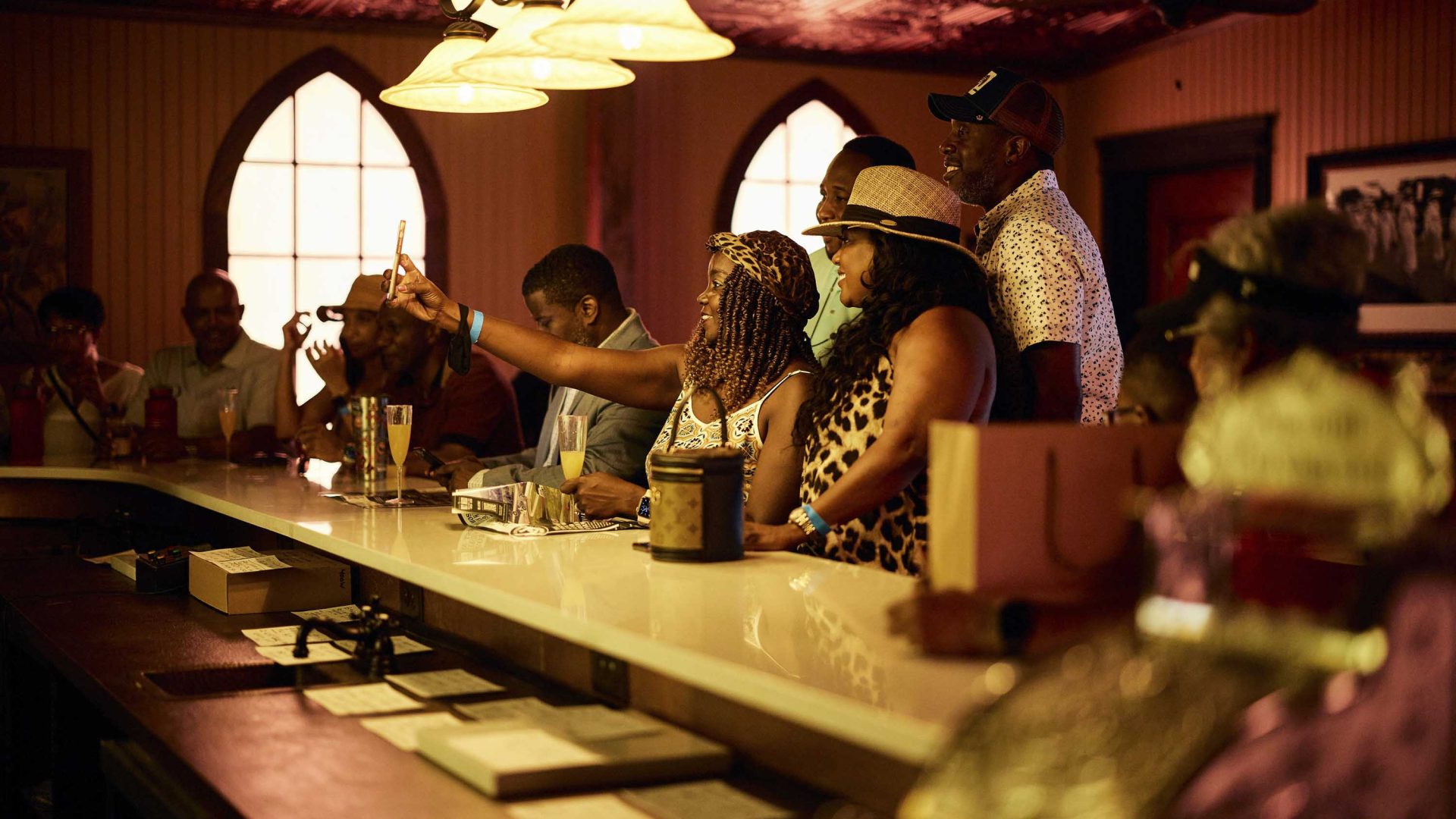 People sit at a bar inside the distillery.