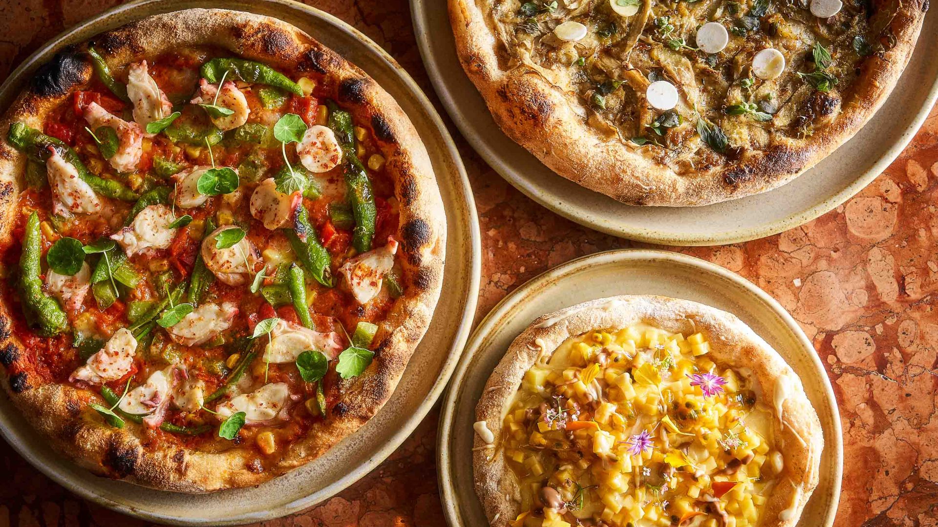 Three different pizzas seen from above.