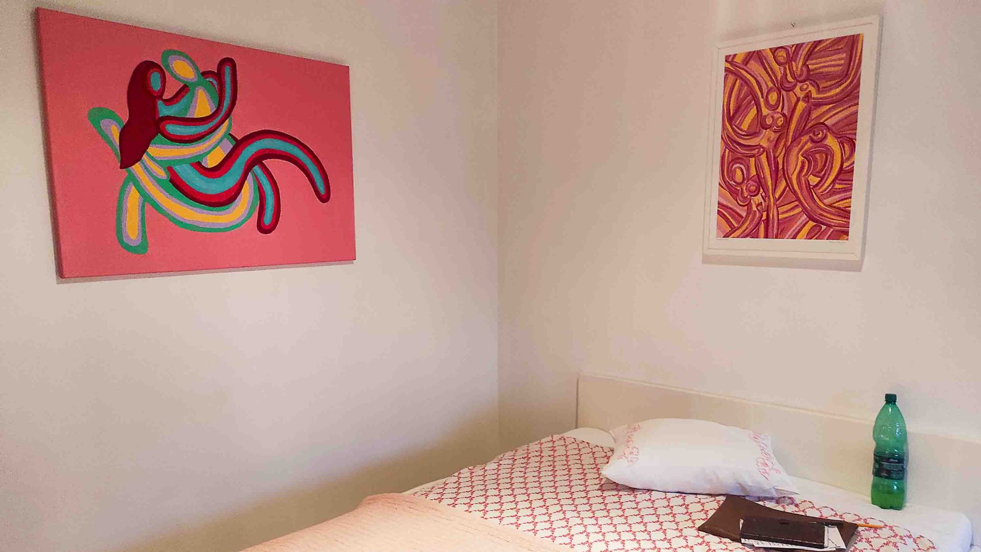 A bed with art on the walls above it.