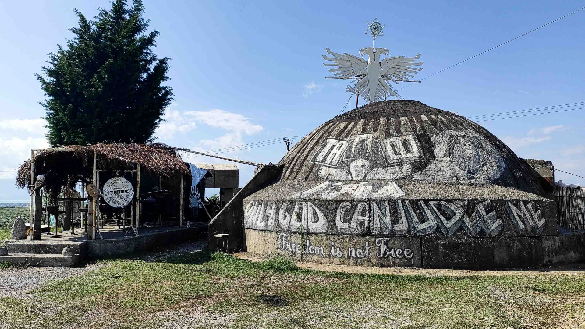 A bunker with the words 'only God can judge' and a sign saying 'Tattoo'.