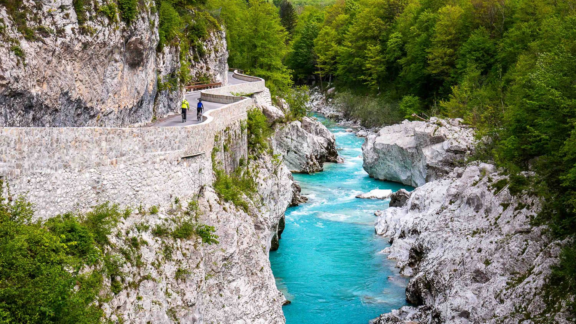 A vibrant blue river with a road running alongside it.