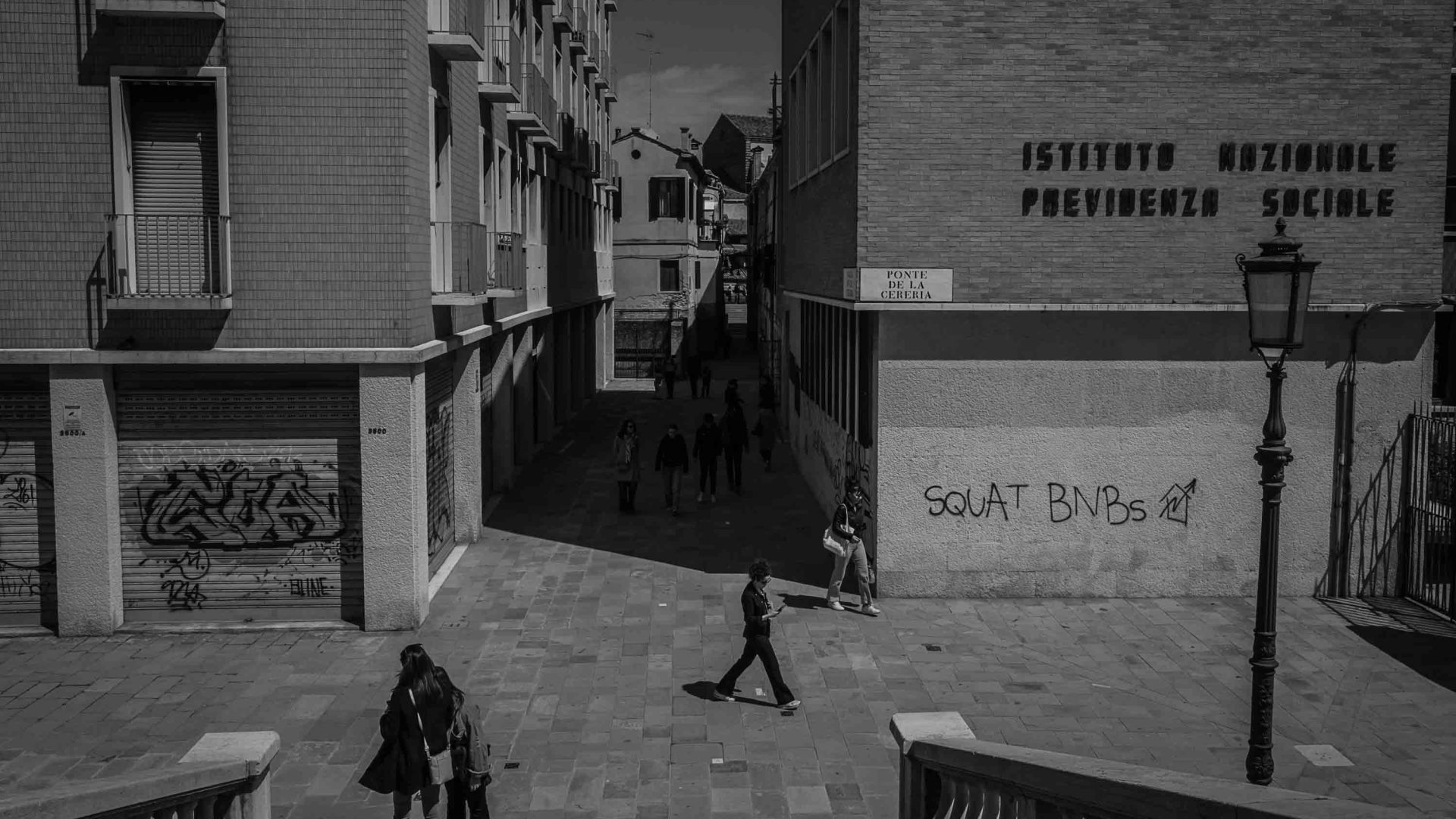 Graffiti on the wall of a building says 'Squat B&B's'.