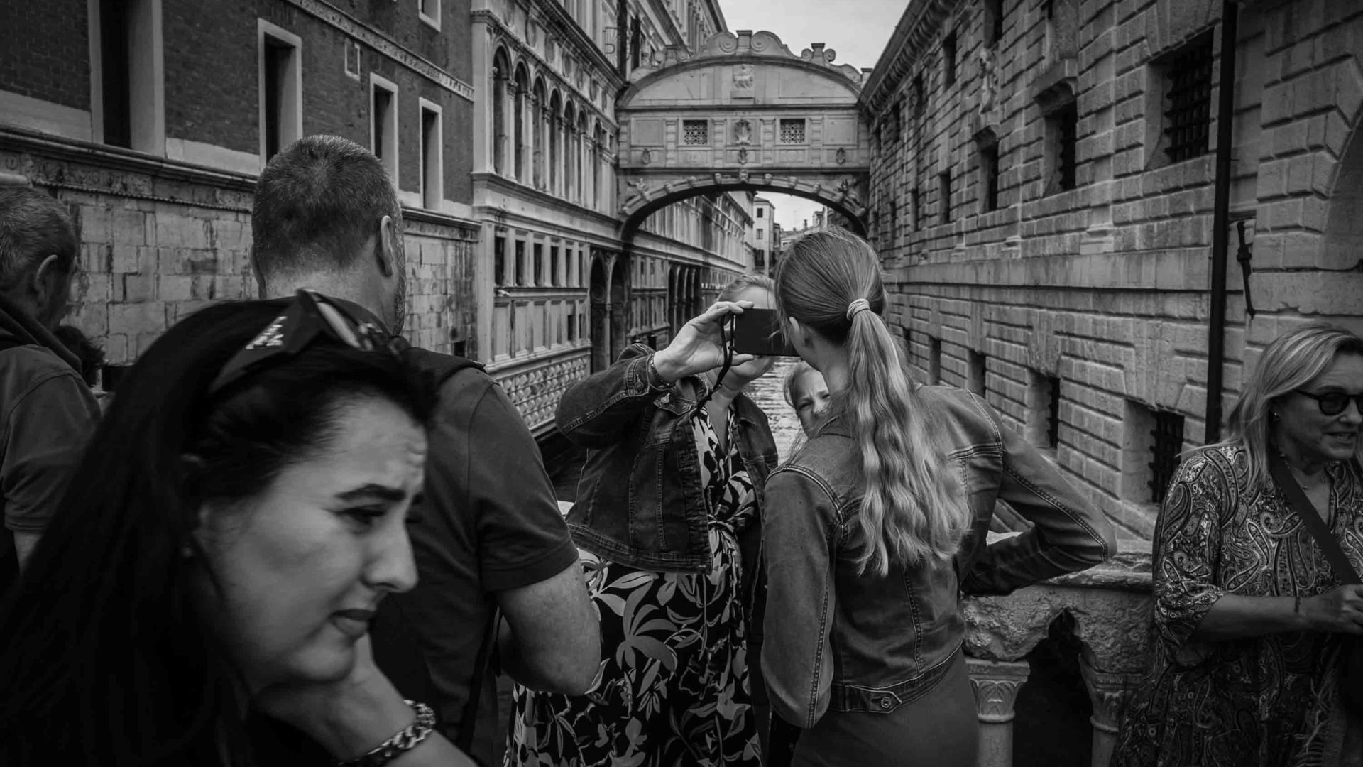 Tourists take photos of the canals in Venice.