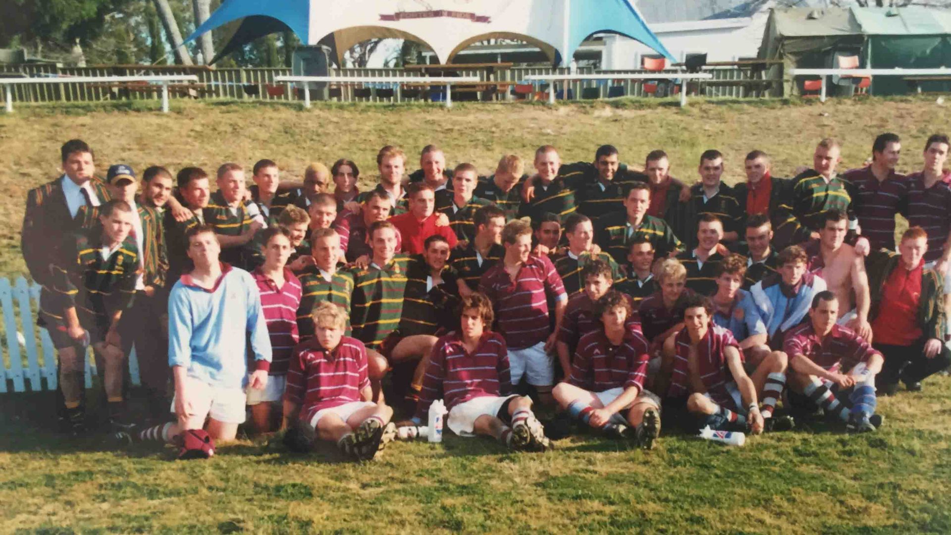 A rugby team being photographed on a sports ground.