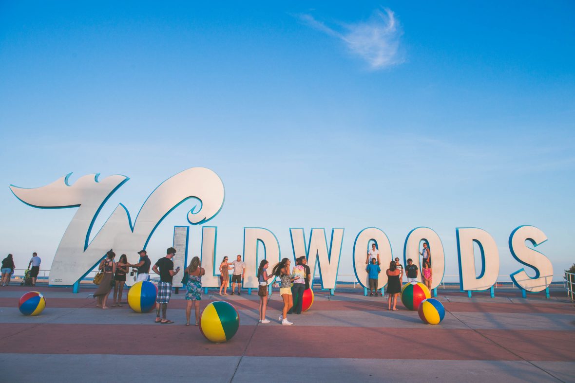 People mill around the Wildwoods sign at the end of the day.