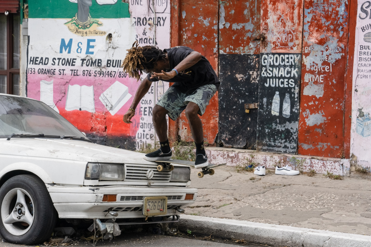 man mid-jump skating over parked car